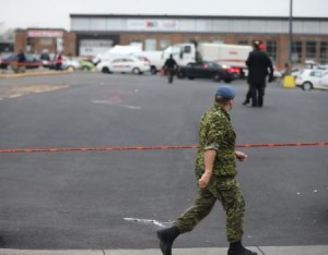 A member of Canada"s armed forces walks past the scene of a hit and run of two soldiers in St. Jean sur Richelieu, Quebec