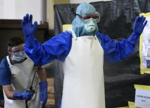 A volunteer of the German army Bundeswehr, wearing a protective suit, is disinfected by a colleague during an Ebola training session at the Marseille barracks in Appen