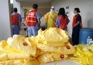 Centers for Disease Control and Prevention (CDC) instructors give guidance on decontamination to health care workers as personal protection equipment lies on a table in the foreground, in preparation for the response to the current Ebola outbreak, during a CDC safety training course in Anniston, Alabama,