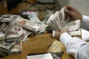 An employee counts money at a bank in Cairo