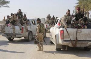 Shi"ite fighters and Iraqi army members ride in vehicles during a patrol in Jurf al-Sakhar
