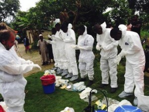 Volunteers prepare to remove the bodies of people who were suspected of contracting Ebola and died in the community in the village of Pendebu