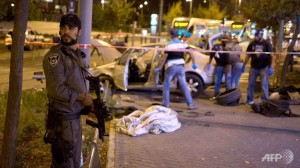 An Israeli policeman stands on guard near the scene after a car rammed a group of pedestrians at the Ammunition Hill tram stop, which lies on the seamline between west and occupied east Jerusalem
