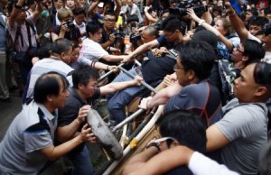 Anti-Occupy Central protesters (L) try to remove a barricade from pro-democracy protesters on a main street in Hong Kong"s