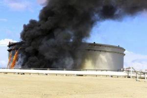 Black smoke billows out of a storage oil tank in the port of Es Sider in Ras Lanuf