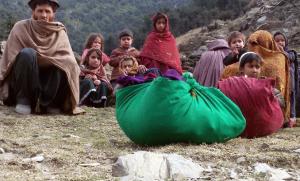  Afghan family sits on the ground after leaving their home during fighting in the Dangam district of Kunar province.