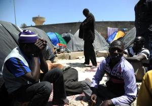 Illegal migrants from Niger sits next to their tents