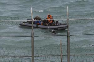 Moroccan soldiers on a boat attempt to board a would be migrant on Moroccan waters near the border fence that separates Spain"s North African enclave of Ceuta from neighbouring Morocco