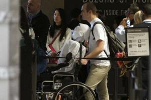 Herzog, a doctoral student at Max Planck Society, pushes 'Athena', the first 'humanoid' robot to fly as a passenger, as they prepare to board a Lufthansa commercial airline flight to Frankfurt, Germany at Los Angeles International Airport