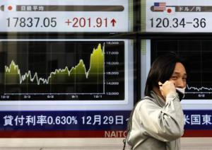 أحد المارة امام شاشة تعرض سعر الين امام الدولار الامريكي في طوكيو