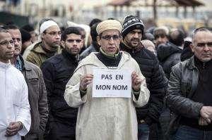 A Muslim man holds a sign reading "Not in my name", during a gathering near the mosque of Saint-Etienne, eastern France, after the attack on the offices of weekly satirical Charlie Hebdo