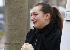 A woman reacts while paying tribute to the victims of a hostage taking outside the Hyper Cacher kosher supermarket near Porte de Vincennes in eastern Paris