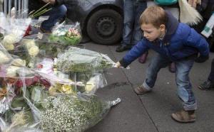A boy places flowers outside the Hyper Cacher kosher supermarket near Porte de Vincennes in eastern Paris,