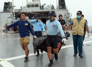 Indonesian's Navy personnel carry a bag containing a dead body of a passenger of AirAsia Flight