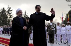 Iranian President Hassan Rouhani (left) shakes hands with Venezuelan President Nicolas Maduro after reviewing the honor guard at the Saadabad Palace in Tehran
