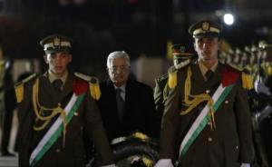 Palestinian President Mahmoud Abbas (C) arrives to lay a wreath on the grave of late Palestinian leader Yasser Arafat during a ceremony marking the 50th anniversary of the founding of the Fatah movement, in the West Bank city of Ramallah