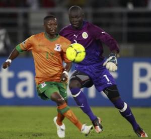 رينفورد كالابا لاعب منتخب زامبيا (يسارا) يتنافس على الكرة مع حارس المرمى السنغالي بونا كوندول