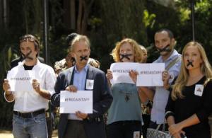 About a dozen Kenya-based journalists staged a small protest against the jailings in front of the minister in the U.N. compound, taping their mouths shut to reflect their view that Egypt was stifling free speech.