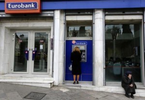 امرأة تسحب اموالا من بنك في اليونان