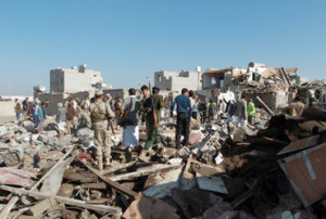 Yemeni Huthi rebels and members of the security forces loyal to the Shiite movement inspect the damage at the scene of a Saudi air strike near Sanaa airport 