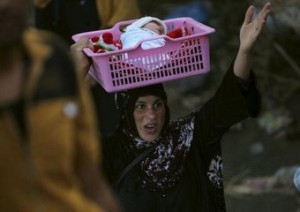 An Iraqi Sunni displaced woman, who fled the violence in the city of Ramadi carries her child on the outskirts of Baghdad