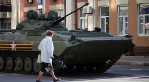 امرأة تسير بمحاذاة دبابة تابعة لانفصاليين شرقي أوكرانيا