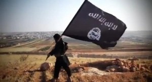 Image grab from a video on August 23, 2013 allegedly shows a member of a jihadist group affiliated to the Islamic State of Iraq and the Levant, holding up the trademark black and white Islamist flag at an undisclosed location