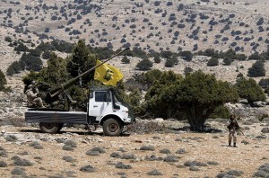 Lebanon's Hezbollah fighters rest on the back of a pick-up truck with an installed weapon in Khashaat, in the Qalamoun region after they advanced in the area
