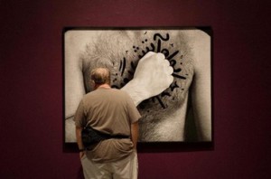 A man views "My House is On Fire" from The Book of Kings series, 2012, by Iranian-born visual artist Shirin Neshat during the exhibit's public opening at the Hirschhorn Art Museum in Washington