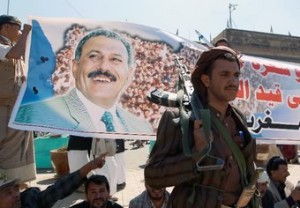Gunmen loyal to Yemen's former president Ali Abdullah Saleh (on the poster) take part in a rally to protest threatened UN sanctions against the ousted strongman and insurgent chiefs