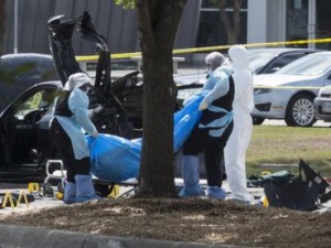 The bodies of two gunmen are removed from behind a car during an investigation by the FBI and local police in Garland, Texas