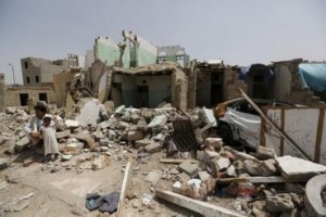 رجل يجلس مع ابنه في موقع ضربته غارة جوية بقيادة السعودية الشهر الماضي
