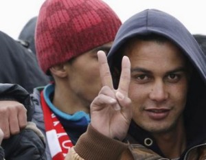 Moroccan citizen Touil Abdelmajid makes a victory sign as he arrives with migrants on the Italian navy ship Orione at Porto Empedocle harbour in Sicily February 17, 2015. Italian police said