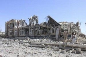 Houthi militants stand near a government building destroyed by a Saudi-led air strike in Yemen"s northwestern city of Saada