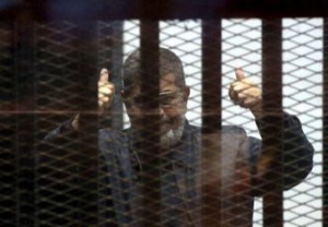 الرئيس المصري المخلوع محمد مرسي خلف القضبان خلال محاكمته بالقاهرة 
