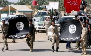 Shi"ite paramilitary fighters hold an Islamist State flag which they pulled down during victory celebrations after returning from Tikrit in Kerbala, southwest of Baghdad
