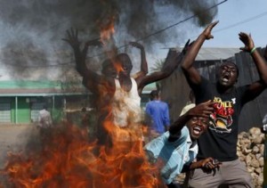 Protesters, who are against President Pierre Nkurunziza"s decision to run for a third term, gesture in front of a burning barricade in Bujumbura, Burundi