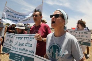 Israeli peace activists hold banners and shout slogans as they demonstrate against the demolition of the Palestinian village of Susya