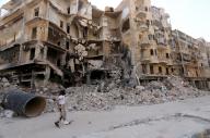 رجل يمر بمباني مدمرة في حلب 