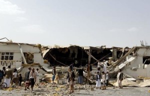 شخاص يتجمعون خارج مصنع دمرته غارة جوية بقيادة السعودية