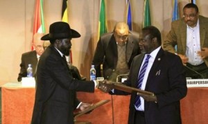 South Sudan"s President Salva Kiir (front L) and South Sudan"s rebel commander Riek Machar exchange documents after signing a ceasefire agreement during the Inter Governmental Authority on Development (IGAD) Summit on the case of South Sudan in Ethiopia"s capital Addis Ababa