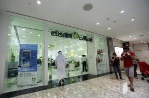 Customers walk past an Etisalat store at a shopping mall in Dubai