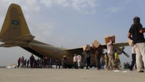 عمال يقومون بتفريغ شحنات مساعدات من طائرة عسكرية سعودية في عدن ي
