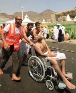 Saudi emergency personnel and hajj pilgrims push an injured man in a wheelchair at the site of the tragedy