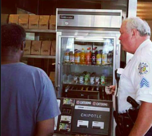 Police Officer Pictured Buying Food For Homeless Man Digging Through Rubbish