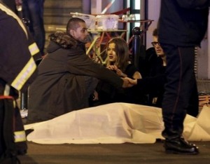 A general view of the scene that shows rescue services personnel working near the covered bodies outside a restaurant following a shooting incident in Paris