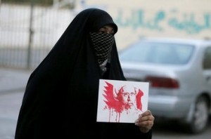 محتجة ترفع صورة لرجل الدين الشيعي نمر النمر خلال احتجاج في البحرين 