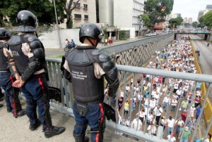 Police officers look on as opposition supporters take part in a rally to demand a referendum to remove Venezuela's President Nicolas Maduro in Caracas, Venezuela