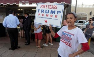 Madelyn del Rio, from Dominican Republic, holds a sign up in front of the Cuban popular Cafe Versailles in the Little Havana district as U.S. President Donald Trump is expected to announce changes to U.S.-Cuba policy, in Miami, Florida 