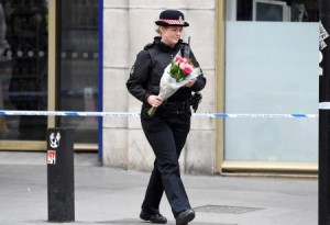 A police woman carries flowers near London Bridge after an attack left 7 people dead and dozens injured in London, Britain 